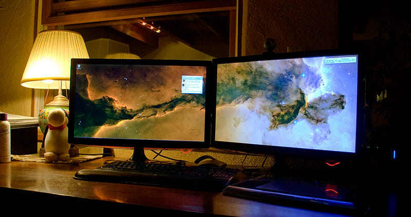 two monitors and a lamp