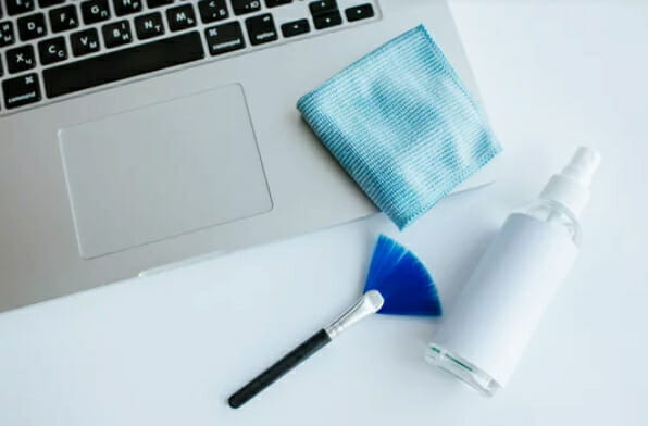 brush, spray and cloth on laptop